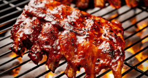 Grilled beef back ribs with BBQ sauce cooking over flame at John Mull’s Meats