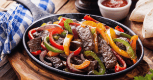 Sizzling beef fajitas with colorful peppers and onions at John Mull’s Meats