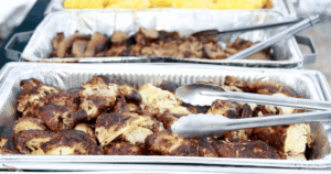 Smoked meats and BBQ chicken trays set up for BBQ catering at a Las Vegas event by John Mull’s Meats