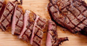 Sliced barbecue grilled ribs with smoke rings and sear marks on a wooden cutting board