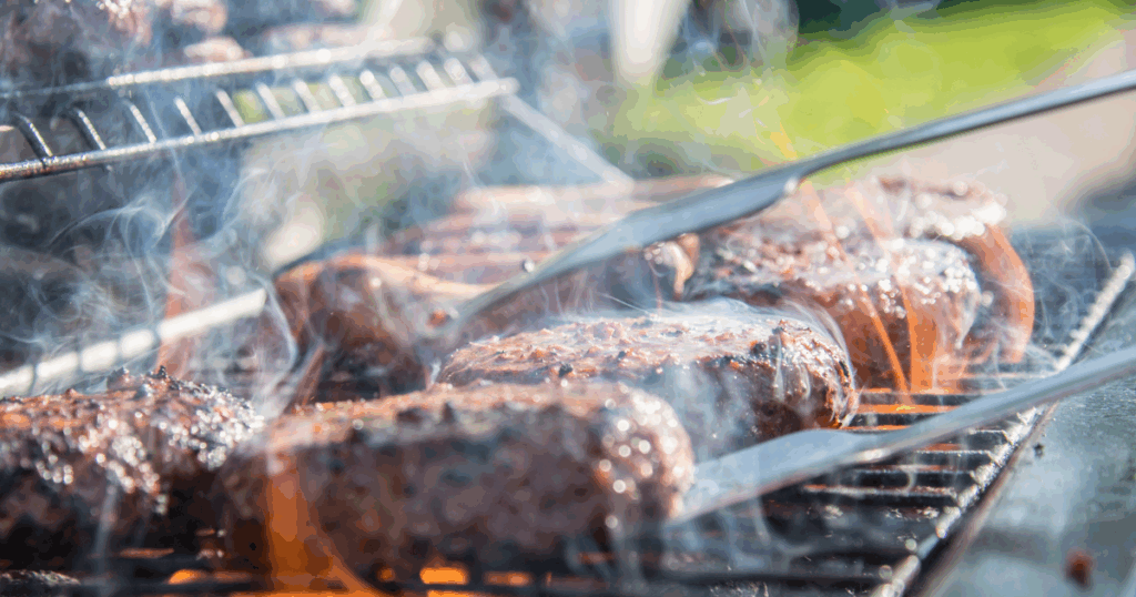 Juicy BBQ meats grilling over open flames as the perfect host prepares a summer cookout