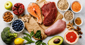 Assorted lean meats including salmon, chicken, and beef paired with legumes, nuts, eggs, and vegetables — ideal for a high-protein diet and health benefits.