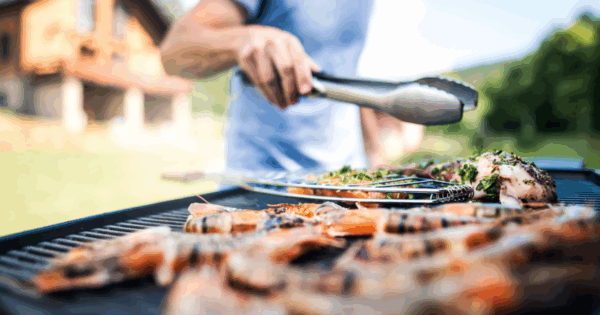 Grilling seasonal shrimp and meats on an outdoor BBQ grill during summer at John Mull’s Road Kill Grill
