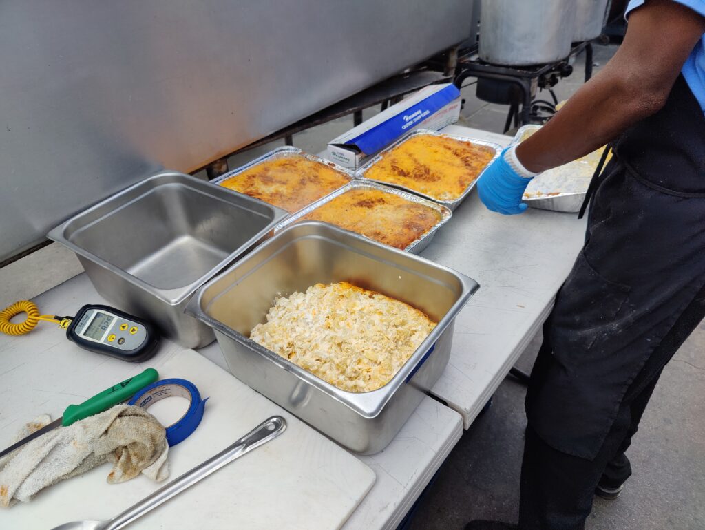 Prepared BBQ side dishes including mac and cheese being assembled by staff at John Mull’s Road Kill Grill in Las Vegas