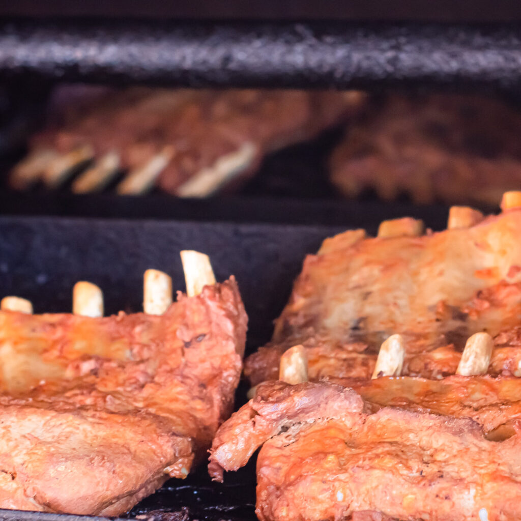 Seasonal BBQ meats smoking inside the wood-fired smoker at John Mull’s Road Kill Grill in Las Vegas

