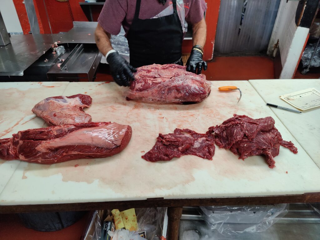 Butcher preparing fresh meat cuts at John Mull’s Meats in Las Vegas