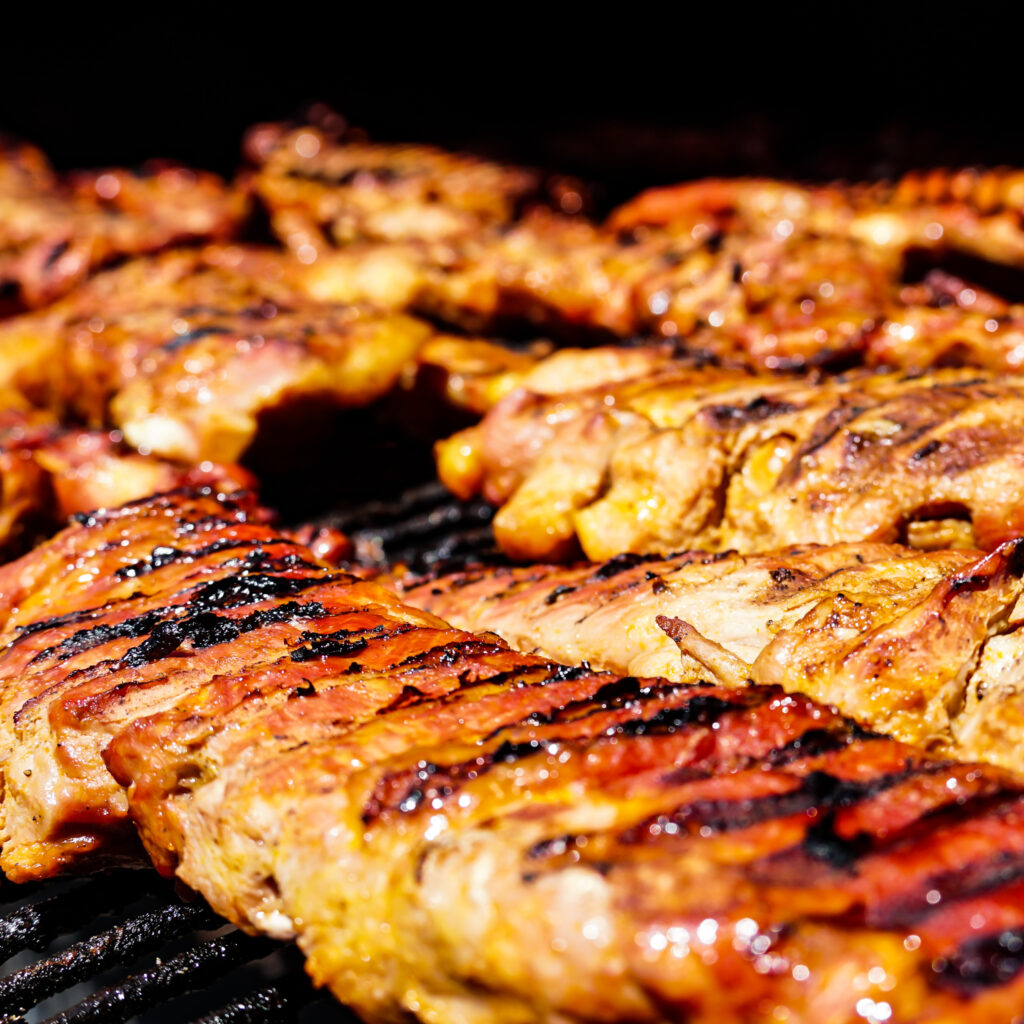 "Slow-smoked pork ribs being prepared at John Mull’s Road Kill Grill in Las Vegas BBQ pit"