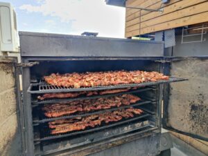 Pitmaster adding flavor to smoked rib tips at Road Kill Grill in Las Vegas