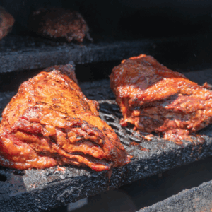 Juicy smoked brisket cooking slow on a black smoker at John Mull’s Road Kill Grill in Las Vegas