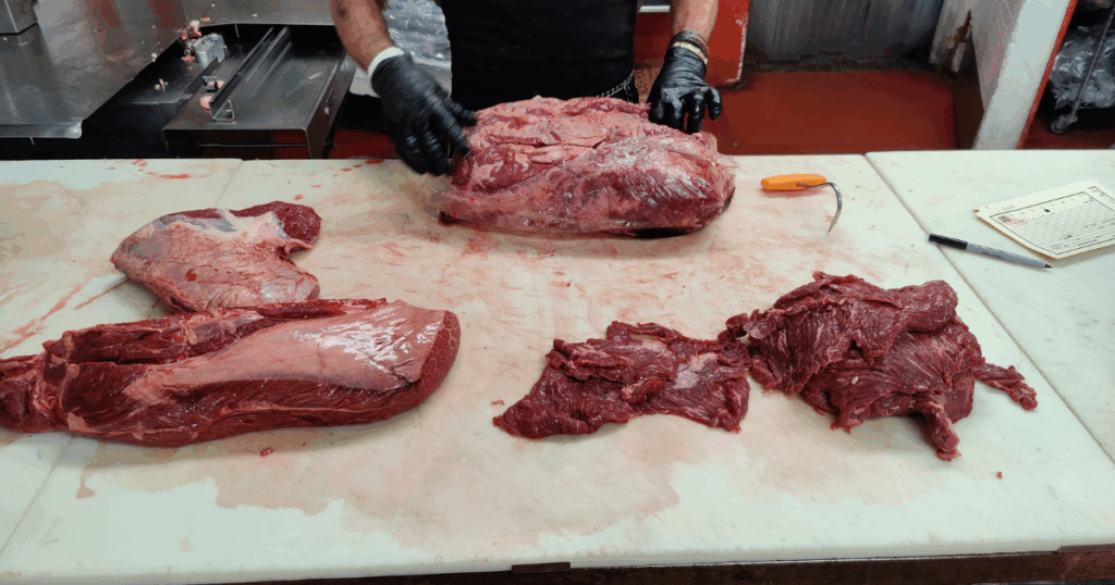 Butcher preparing fresh beef cuts by hand at John Mull’s Meats in Las Vegas. Way better than any grocery store.
