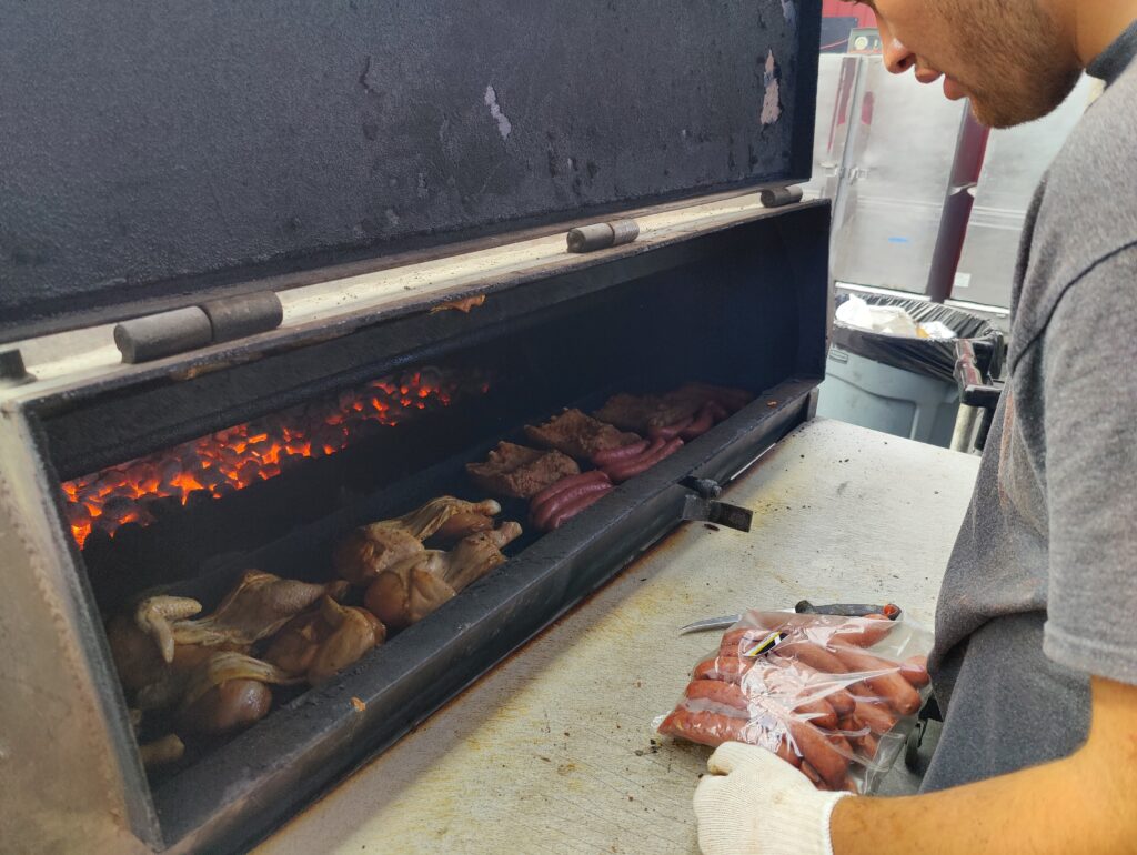 Grillmaster preparing smoked sausages, BBQ chicken, and ribs at John Mull’s Road Kill Grill Las Vegas – must-try BBQ menu items