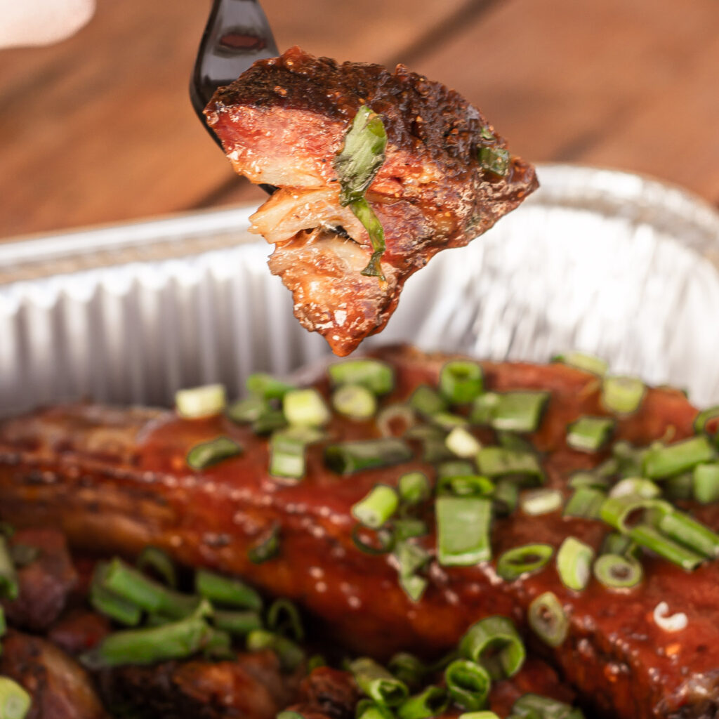 Close up of tender rib tip coated in barbecue sauce and green onions at this hidden gem at John Mull’s Road Kill Grill in Las Vegas.
