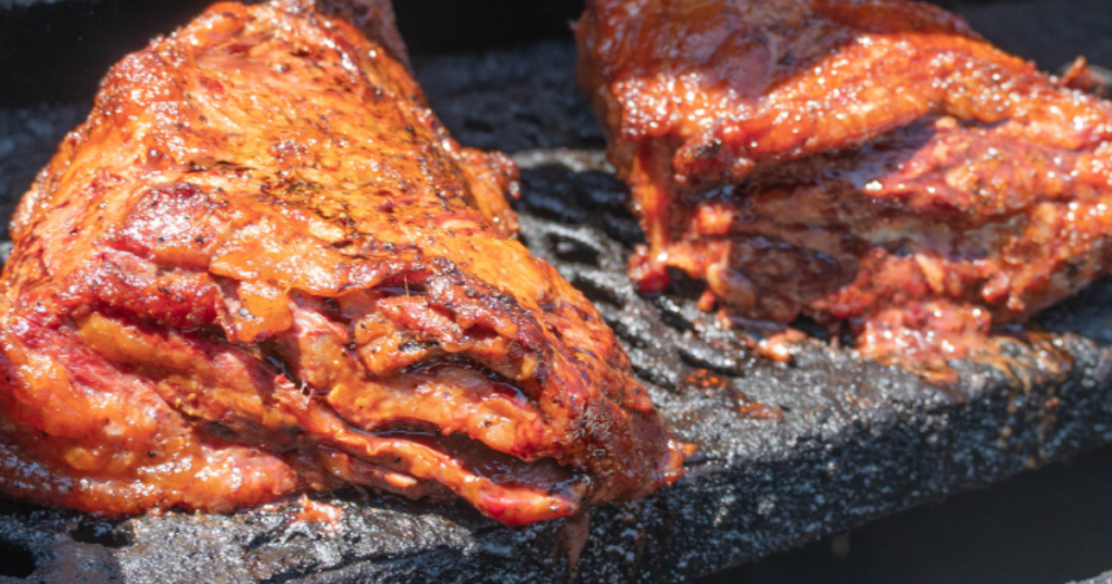 slow-smoked BBQ pork on the grill for affordable BBQ catering in Las Vegas.