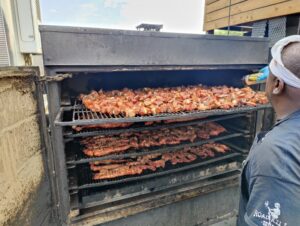 Road Kill Grill team members preparing smoked meats for Las Vegas BBQ catering and large event meals.