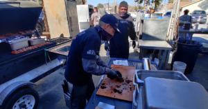 John Mull’s Road Kill Grill team preparing smoked meats outdoors at a Las Vegas BBQ restaurant known for family-friendly outdoor dining.