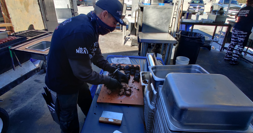 John Mull’s Road Kill Grill team preparing smoked meats for Las Vegas BBQ catering and large event meals.