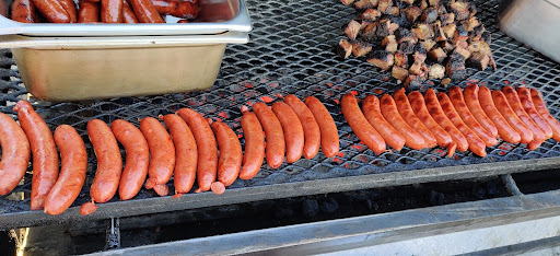 Smoked sausages and BBQ meats cooking on the grill for Las Vegas BBQ catering by John Mull’s Road Kill Grill.