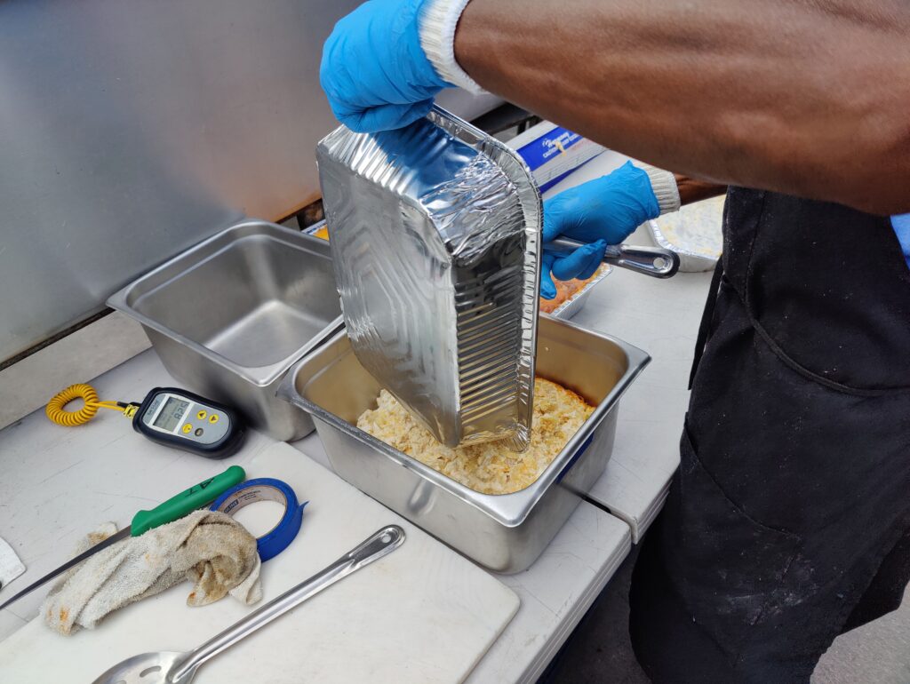 Preparing homemade macaroni and cheese for BBQ catering Las Vegas events at John Mull's Meats Road Kill Grill.